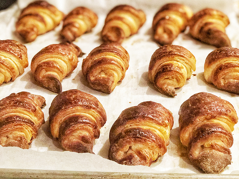 A baking tray full of crispy golden croissants